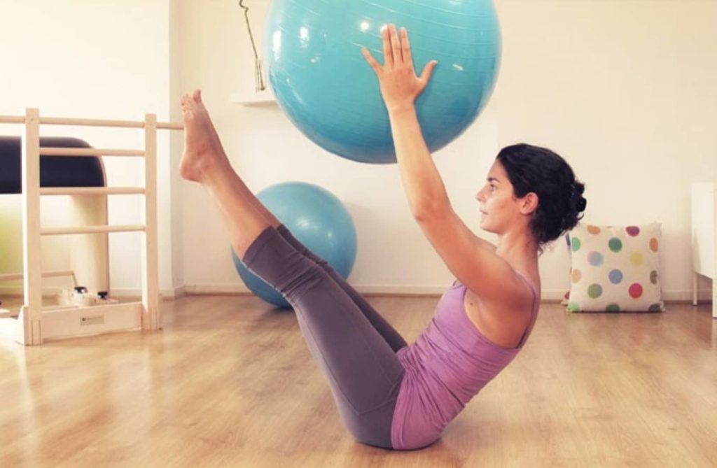 Pratiquante de Pilates tenant un gymball dans ses mains