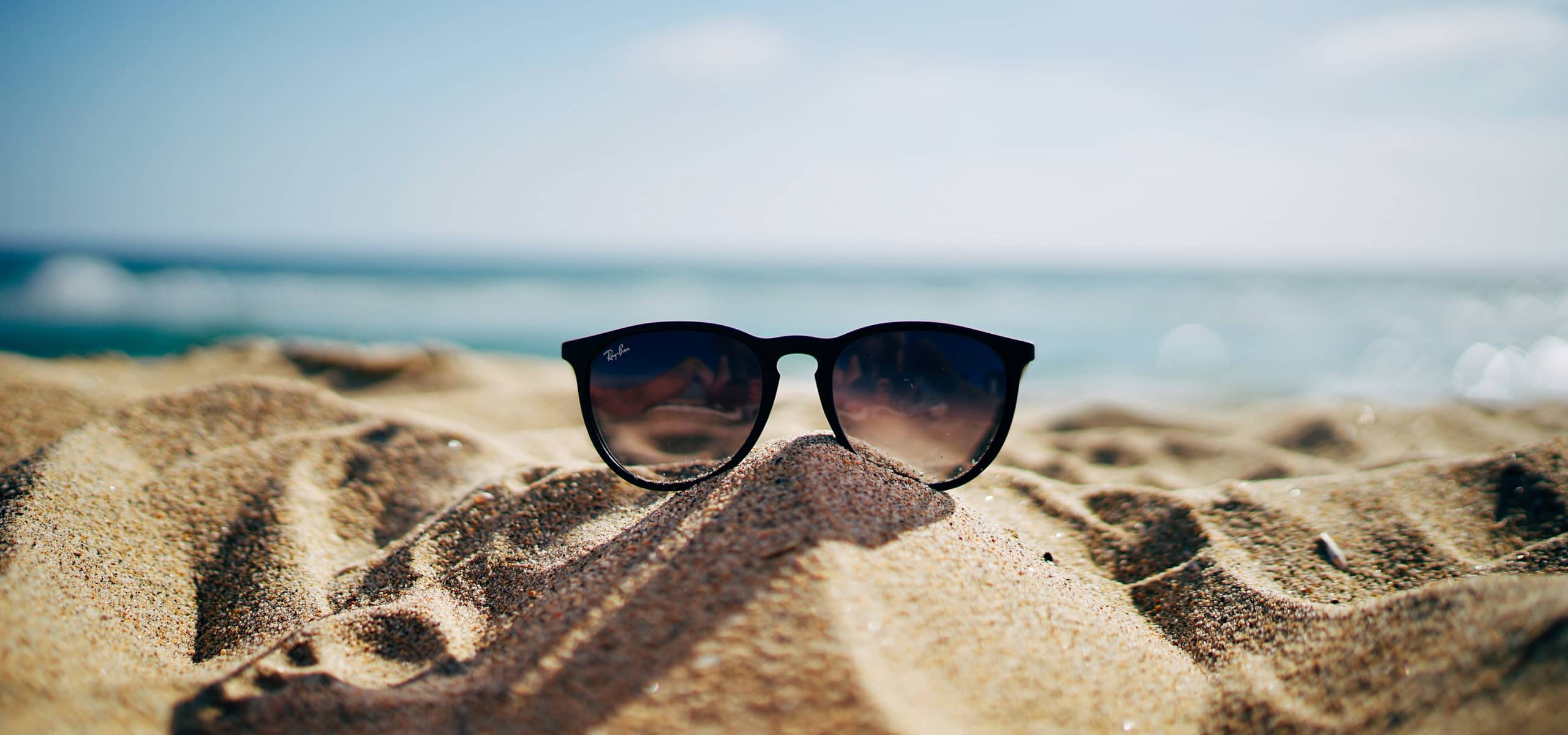 Des lunettes de soleil dans le sable